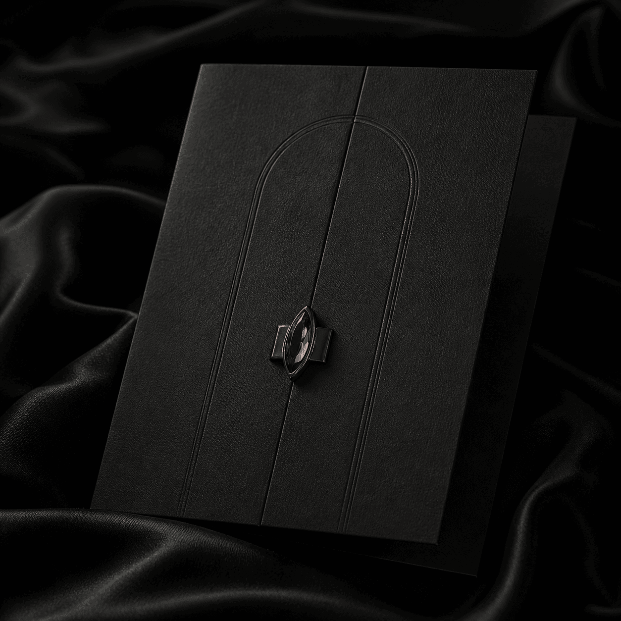 A black invitation sealed by a single red marquise stone